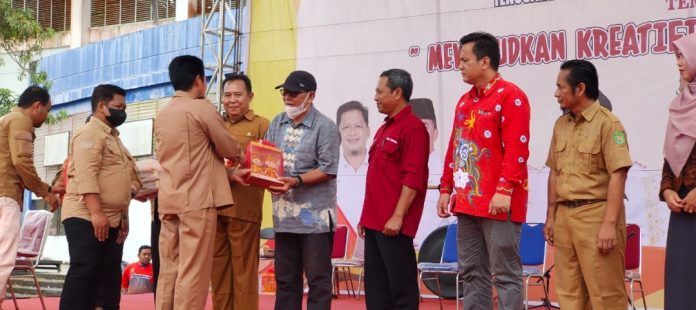 Asisten III Setkab Kukar, Totok Heru Subroto saat menyerahkan cendera mata ke perwakilan masing-masing kabupaten/kota peserta jambore. (Muhammad/Radar Kukar)