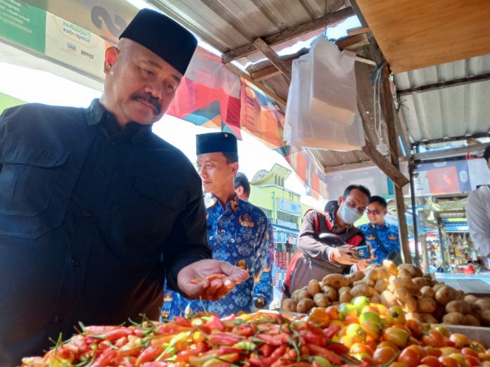 Bupati Kukar, Edi Damansyah, saat mengunjungi lapak pedagang untuk memastikan harga dan ketersediaan bahan pokok di Pasar Mangkurawang. (Ady/Radar Kukar)