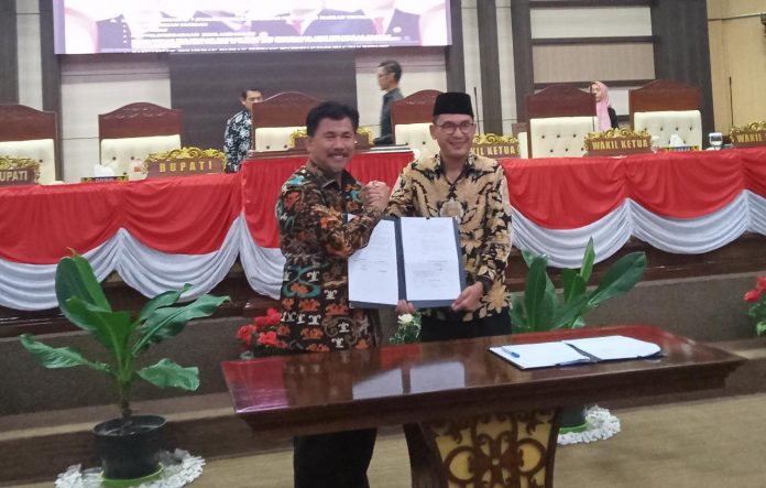 Sekkab Kukar, Sunggono, (kiri) bersama dengan Wakil Ketua DPRD Kukar, Alif Turiadi. Saat menandatangani berita acara Rapat Paripurna. (Ady/Radar Kukar)