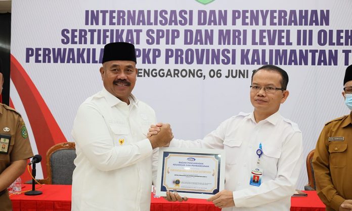 Bupati Kukar, Edi Damansyah (kiri), saat menerima piagam penghargaan SPIP dan MRI Level III Sakal 1-5 dari BPKP RI, yang diserahkan oleh Kepala BPKP Perwakilan Provinsi Kaltim, Hasoloan Manalu. (Istimewa)