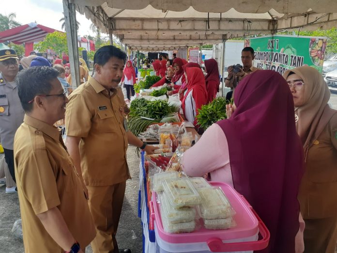 Sekkab Kukar, Sunggono, saat berkunjung di pasar murah yang digelar di Halaman Parkir Kantor Bupati Kukar. (Ady/Radar Kukar)