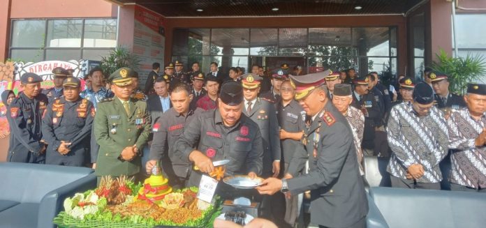 Bupati Kukar, Edi Damansyah, (Kiri) saat memberikan potongan tumpeng perayaan Hari Bhayangkara ke-77 pada Kapolres Kukar, AKBP Hari Rosena. (Ady/Radar Kukar)