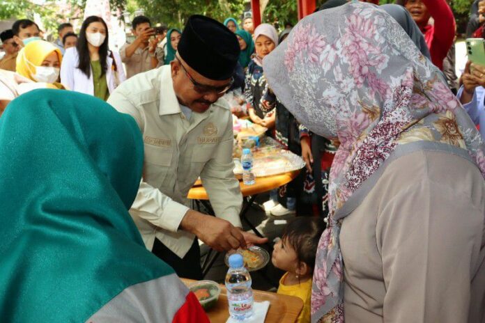 Bupati Kukar, Edi Damansyah, saat memberikan asupan makanan pada balita di Kecamatan Loa Kulu. (Istimewa)