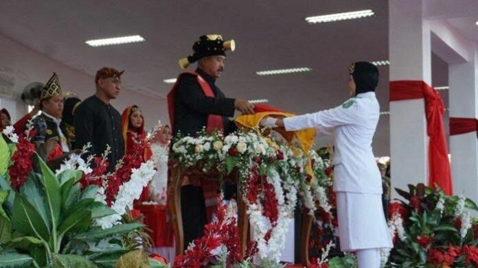 Edi Damansyah saat mengenakan pakaian adat di upacara penurunan bendera. (Istimewa)