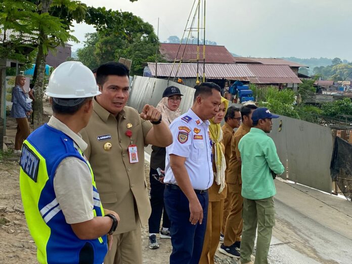 Pjs Bupati Kukar, Bambang Arwanto saat meninjau jalan yang ambles di Desa Jembayan (Ady/Radarkukar)