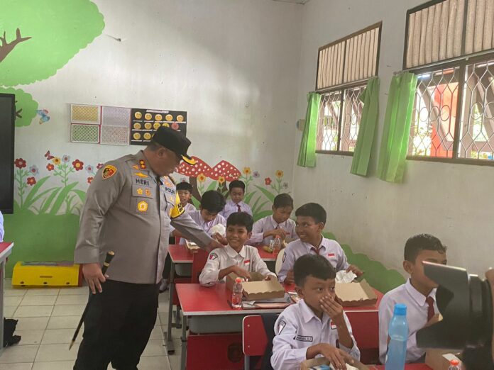 Suasana penyaluran makan siang bergizi dari Polres Kukar di SDN 007 Tenggarong. (Ady/Radarkukar)