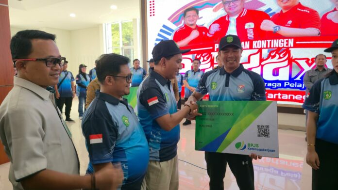 Kepala Kantor Cabang BPJS Ketenagakerjaan Kukar, Eka Suryadi (paling kiri) saat menyerahkan Program BPJS Ketenagakerjaan. (Dokumentasi RadarKukar)