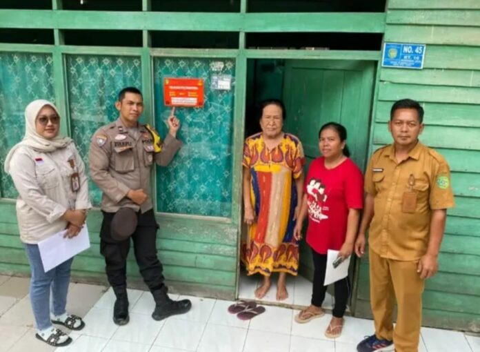Pemasangan stiker di rumah warga penerima bantuan. (Istimewa)