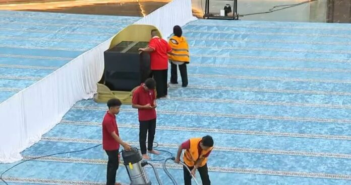 Petugas membersihkan karpet ruang salat utama Masjid Negara di IKN. (Istimewa)