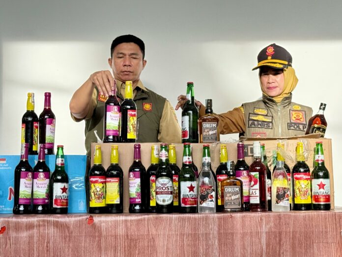 Personel Satpol PP Kota Samarinda mengamankan sejumlah botol minuman keras, termasuk jenis arak. (Dok MKN)