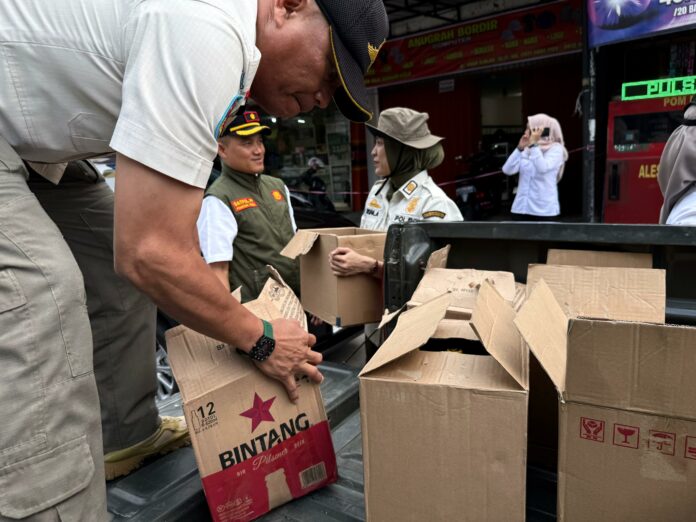 Personel Satpol PP mengamankan puluhan botol miras di salah satu warung Jalan Imam Bonjol. (Dok MKN)
