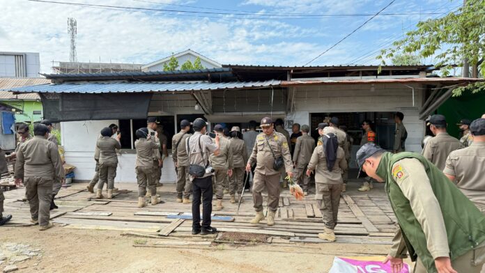 Personel Satpol PP melakukan pembongkaran warung yang berdiri di tanah Pemkot. (Dok MKN)